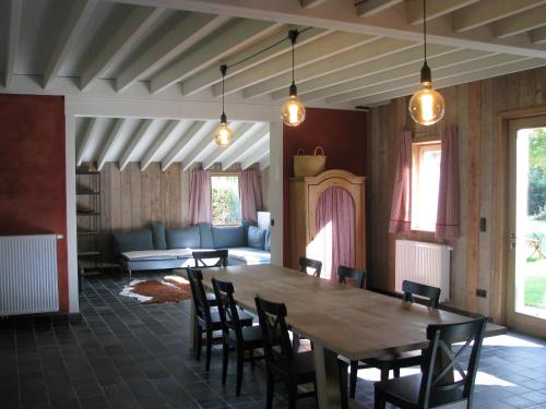 a room with a table and chairs and a couch at B&B Le Plat Pays Oostkamp-Brugge in Oostkamp