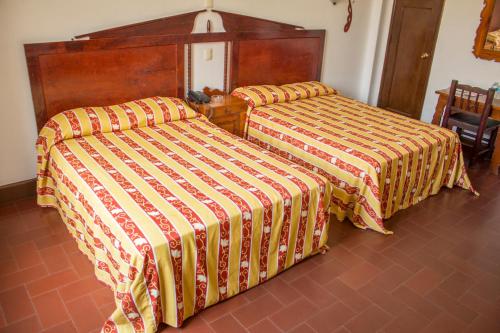 two beds sitting next to each other in a room at Hotel Colonial in Manzanillo