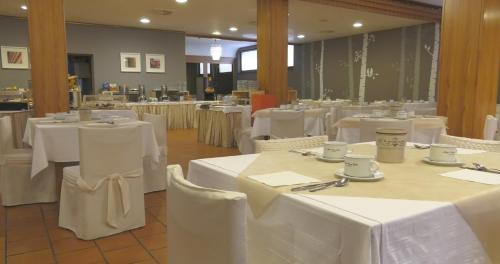 a dining room with white tables and chairs at Hotel Centro Benessere Gardel in Arta Terme