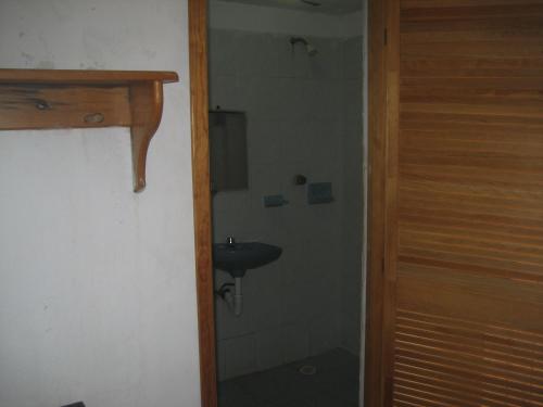 a small bathroom with a sink and a shower at Posada Brisa Marina in Zipolite