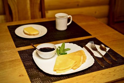 ein Tisch mit zwei Tellern Essen und einer Tasse Kaffee in der Unterkunft Lavina Hotel in Bukowel