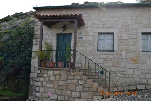 a stone house with a door and a balcony at Casa da Maria in Monsanto