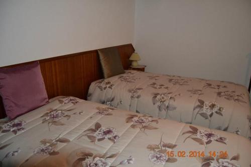 a bed with a blanket with flowers on it at Casa da Maria in Monsanto