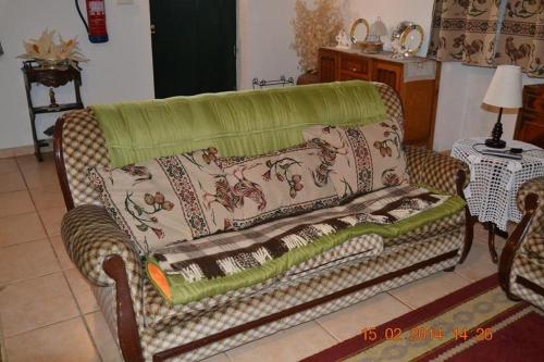 a couch with a blanket on it in a living room at Casa da Maria in Monsanto
