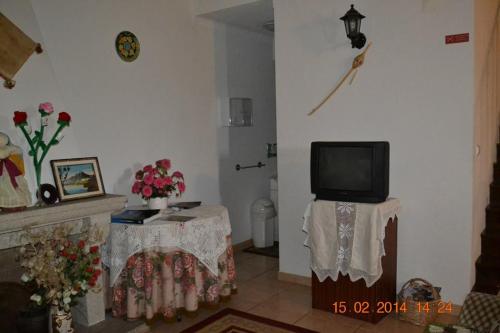 a living room with a tv and a fireplace at Casa da Maria in Monsanto