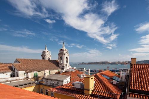 a view of a city with roofs and a church at FeelingLisbon Tejo in Lisbon