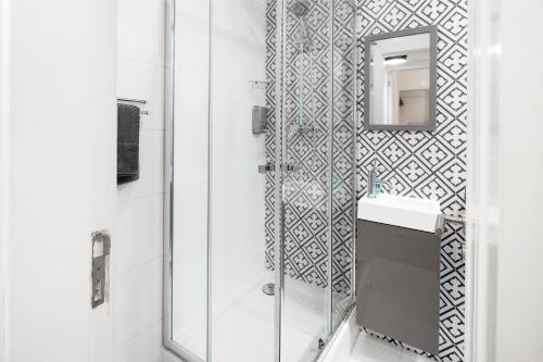 a bathroom with a shower and a sink and a mirror at FeelingLisbon Tejo in Lisbon
