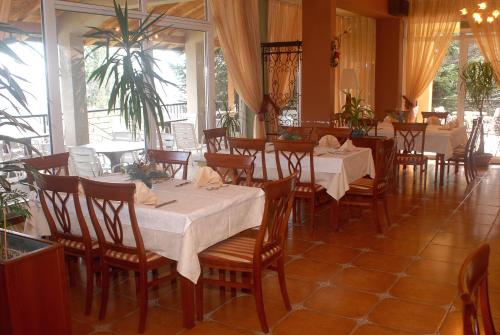 ein Esszimmer mit zwei Tischen und Stühlen in einem Restaurant in der Unterkunft Hotel Šator in Bitola