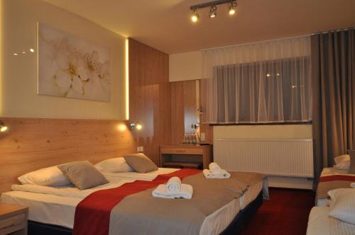 Pass Hotel في Zebrzydowice: غرفه فندقيه بسريرين وعليها قبعات