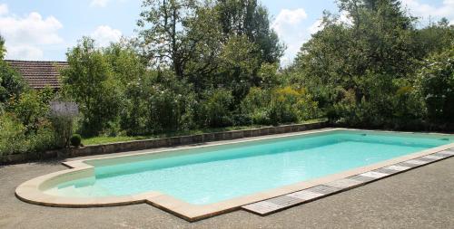 einen Pool in einem Garten mit Bäumen in der Unterkunft Chambres d'hôtes La Distillerie B&B in Saint-Germain-du-Bois