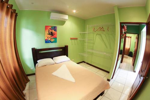 1 dormitorio con cama y pared verde en Casa la Fortuna 1, en Fortuna