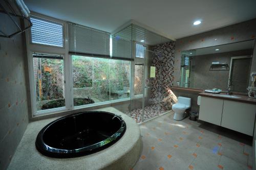 新竹市的住宿－金座渡假汽車旅館，带浴缸和卫生间的大型浴室