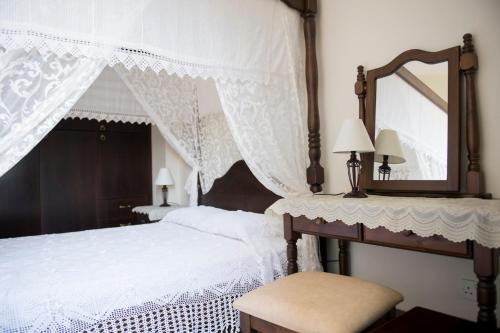um quarto com 2 camas brancas e um espelho em Agrepavli Lapithia em Kallepia
