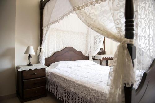 a bedroom with a canopy bed and a dresser at Agrepavli Lapithia in Kallepia
