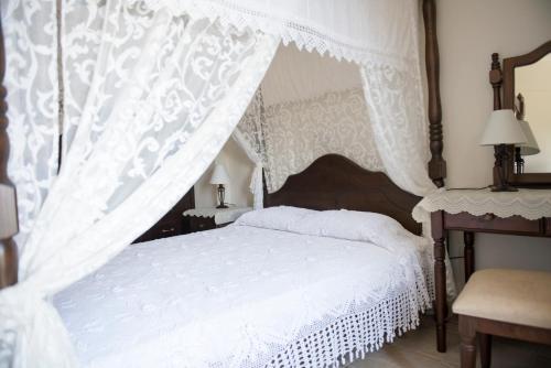 a bedroom with a white bed with a canopy at Agrepavli Lapithia in Kallepia