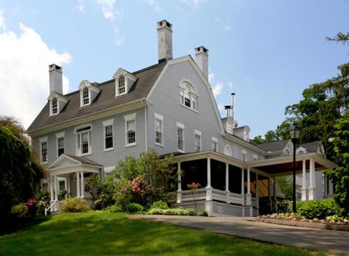a large white house with a lawn in front of it at Simsbury 1820 House in Simsbury