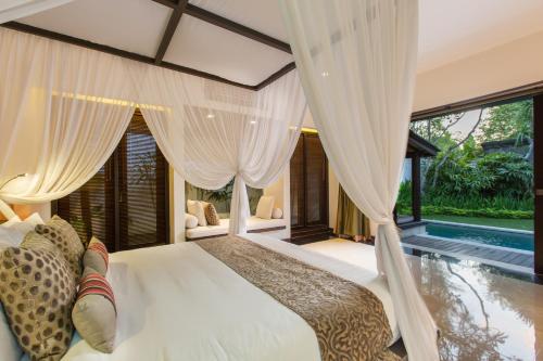 a bedroom with a bed and a swimming pool at Villa Air Bali Boutique Resort and Spa in Seminyak