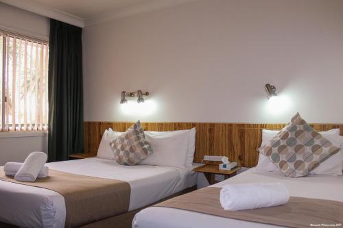um quarto de hotel com duas camas e uma janela em Motel Riverina em Leeton