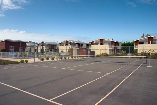 a parking lot with a tennis court and a tennis racquet at Beachside Resort Motel Whitianga in Whitianga