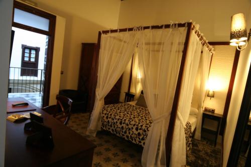 a bedroom with a bed with a canopy at Hostal Palacio San Bartolomé in El Puerto de Santa María