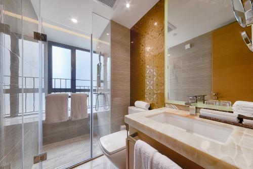 a bathroom with a sink and a glass shower at Heefun International Apartment - Zhujiang New Town FuLi Brand New World Plaza in Guangzhou