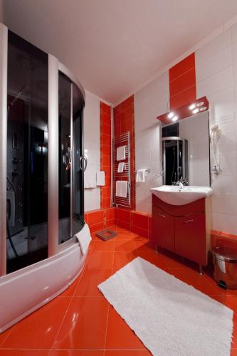 a red bathroom with a sink and a mirror at Hotel Royal Craiova in Craiova