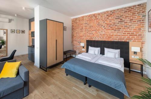 a bedroom with a bed and a brick wall at Aparthotel BC 29 Residence in Kraków