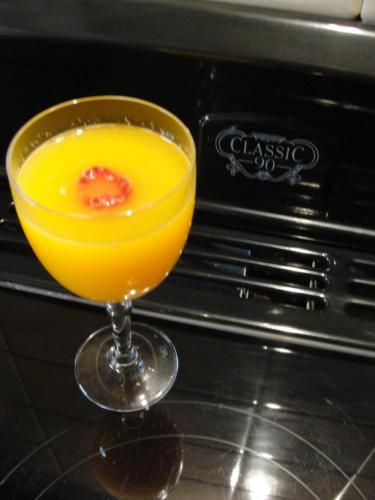 a glass of orange juice sitting on a table at B&B Hedera in Herne