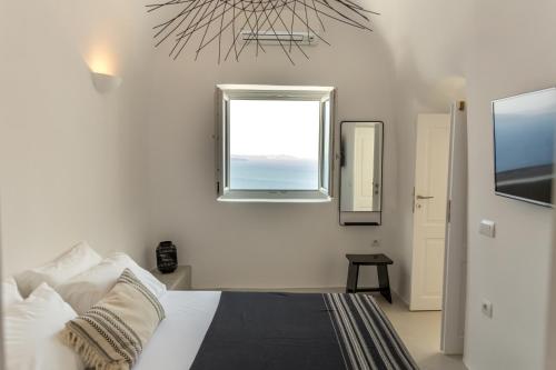 a bedroom with a bed and a window at Delta Suites in Oia