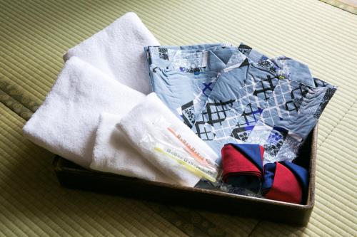 a suitcase filled with white towels and clothes at Yamagata-City AKOYA in Yamagata