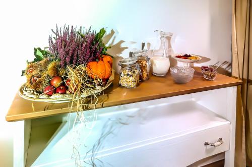 a table with a bowl of fruit and vegetables on it at Foresteria Villa Margherita in Colico