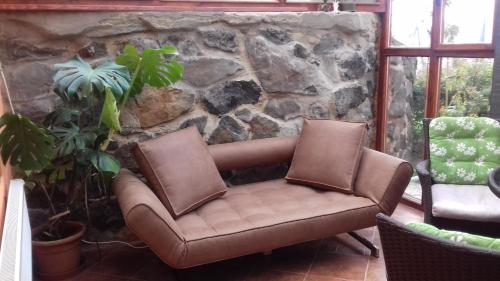 a brown leather chair sitting next to a stone wall at Apartments České Středohoří in Teplice