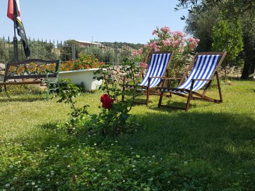 two chairs sitting in the grass in a yard at B&B Nuraximannu in Santadi