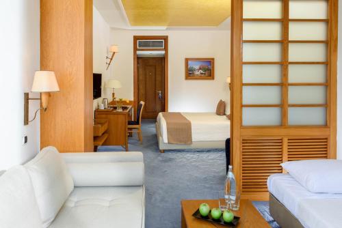 a hotel room with a bed and a living room at Alexander Beach Hotel & Spa in Alexandroupoli