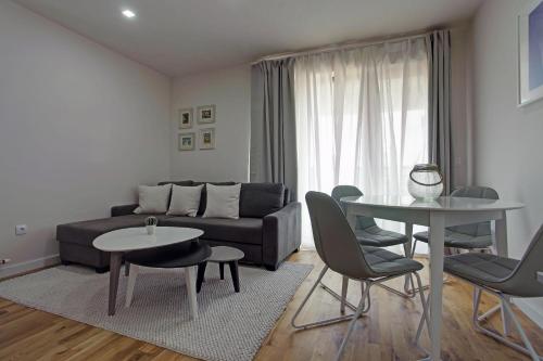 a living room with a couch and a table and chairs at Vip Casa Club Zlatibor in Zlatibor