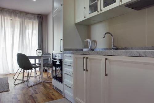 a kitchen with a sink and a table with a chair at Vip Casa Club Zlatibor in Zlatibor