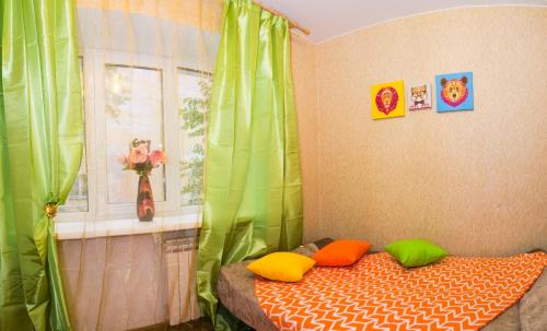 オムスクにあるRENT-сервис Апартаменты на Маркса 48Аのベッドルーム1室(カラフルな枕と窓付)
