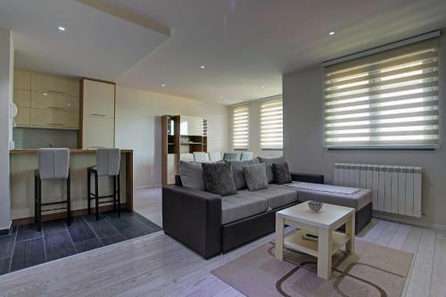 a living room with a couch and a kitchen at Vip Casa Club Zlatibor in Zlatibor