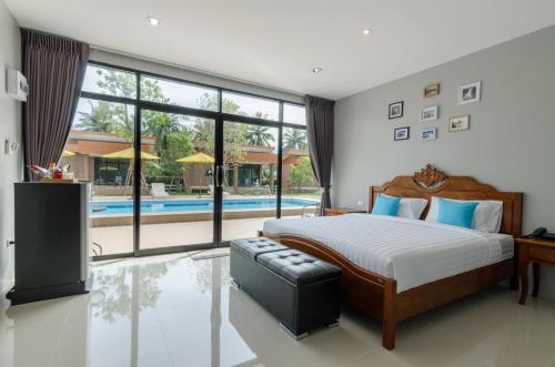 sypialnia z dużym łóżkiem i basenem w obiekcie Golf Inn Resort w mieście Samut Songkhram