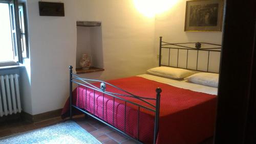 a bedroom with a bed with a red blanket at Short Rent Il Casale in Capolona
