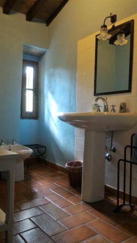 a bathroom with two sinks and a mirror on the wall at Short Rent Il Casale in Capolona
