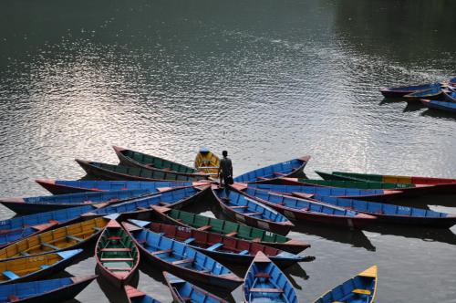 a group of boats lined up in the water at Dahlia Boutique Hotel in Pokhara