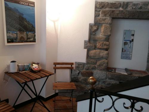 um quarto com uma mesa e uma parede de pedra em La Ginestra em Corniglia
