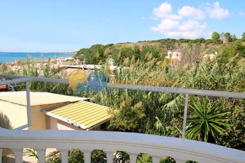 a balcony with a view of a beach and the ocean at Santa Barbara Lakis Apartments in Perivolion