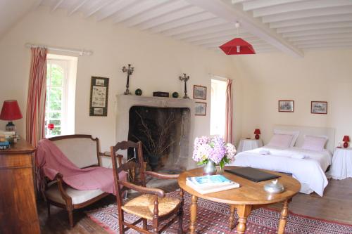 un soggiorno con un letto e un tavolo di Chateau de Flottemanville a Flottemanville