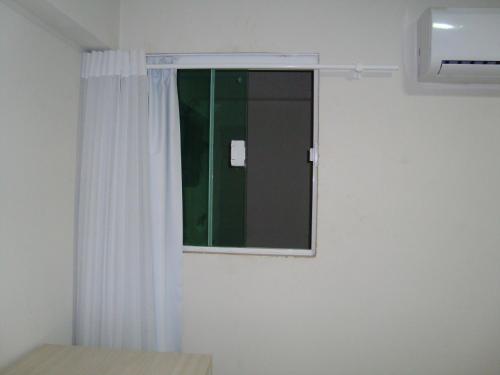 a bedroom with a window and a mirror at Hotel Litoral Fortaleza in Fortaleza
