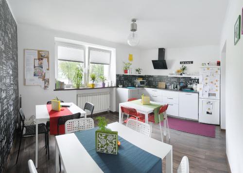 a kitchen with two tables and chairs and a kitchen with at 7th Room Guest House in Oświęcim