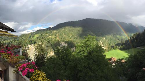 a rainbow in the sky over a mountain at Gasthaus Rössli in Versam