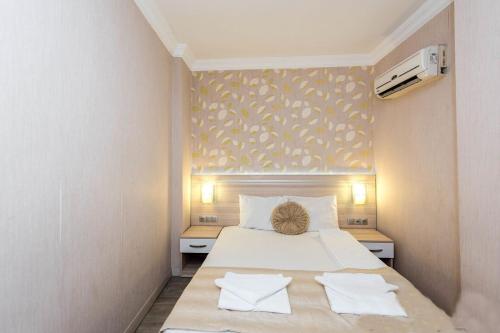 a bedroom with a bed with two towels on it at Olimpiyat Hotel Izmir in Izmir
