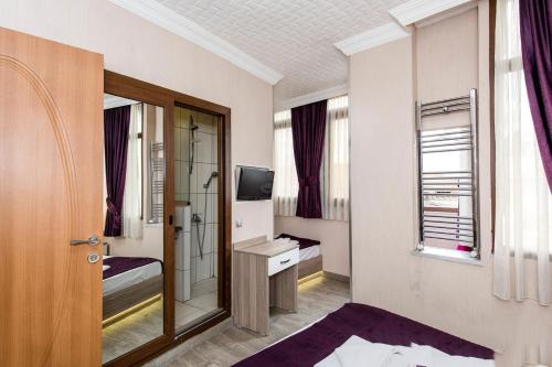 a small room with a bed and a television at Olimpiyat Hotel Izmir in Izmir